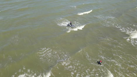 A-jet-Ski-and-a-man-wading-in-the-water-towards-the-shore