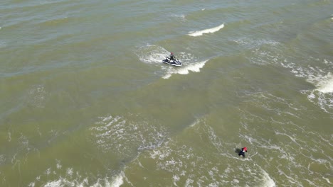 Ein-Jetski-Und-Ein-Mann,-Der-Im-Wasser-In-Richtung-Ufer-Watet