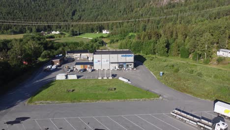 Maxbo-lumber-store-at-Flaa-Norway---Reverse-aerial-during-sunset-with-green-forest-background