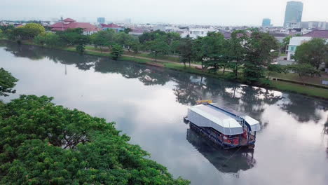 Aerial-Shot-of-Interceptor-Ocean-Cleanup-Machine-Boat-in-Cengkareng-River,-Jakarta-Indonesia