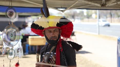 Un-Hombre-De-La-Selva-Amazónica-Toca-Una-Flauta-Tradicional-En-Un-Stand-De-La-Ciudad.