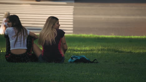 Two-cheerful-young-girls-relaxing-in-the-park-at-Parque-Las-Heras,-Palermo,-Buenos-Aires,-Argentina