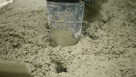 Cement-Construction-Worker-Moving-Wet-Concrete-With-Trowel,-SLOW-MOTION