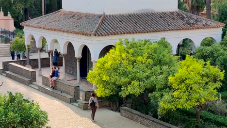 Royal-Alcazar-of-Seville-white-building-with-green-surroundings,-handheld-shot