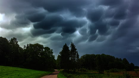 Time-lapse-shot-of-dark-flying-Mammatus-Clouds-at-sky-in-Forest-Landscape-during-storm