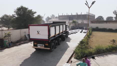 Nuevo-Camión-Volquete-De-Carga-Estacionado-Afuera-De-La-Fábrica-De-Producción-Manufacturera-En-India,-Listo-Para-Salir-A-La-Carretera-Y-Al-Mercado.