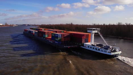 Luftaufnahme-Eines-Millennium-Schiffs-Und-Lastkahns,-Das-Frachtcontainer-Entlang-Der-Oude-Maas-Transportiert