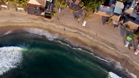 Top-down-aerial-passive-drone-shot-of-Sayulita-beach-in-Mexico-during-golden-sunset-hours