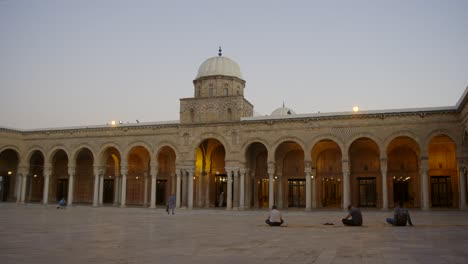 Musulmanes-Sentados-En-El-Suelo-Frente-A-La-Mezquita-Al-zaytuna-En-Túnez,-Túnez-Al-Atardecer