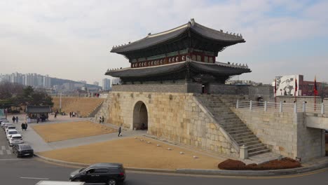 Cars-Traffic-and-travellers-near-Hwaseong-Fortress-North-Gate-in-Suwon-city,-South-Korea-in-winter