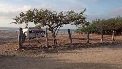 Camper-van-stationed-at-Popoyo-Beach-Nicaragua-close-to-an-access-road,-Wide-handheld-shot