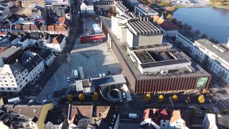 Ascending-aerial-in-city-of-Bergen---Grieghallen-in-between-city-park-with-lungegardswater-and-Lars-Hilles-street