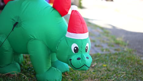 Dinosaurio-Inflable-De-Navidad-Con-Sombrero-Rojo,-Decoración-De-Jardín-De-Navidad-En-Hierba-Verde,-Dinosaurio-Verde-Para-Niños-Pequeños