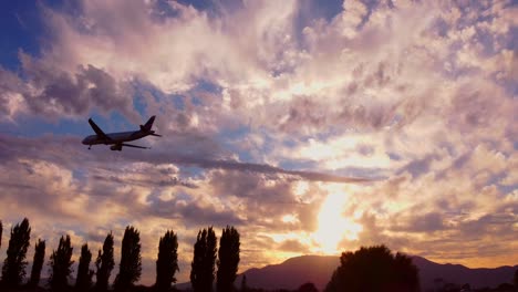 Flugzeuge,-Flugzeug-Nähert-Sich-In-Zeitlupe-Mit-Sonnenuntergang-Im-Hintergrund
