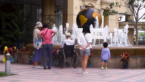 Chinos-Asiáticos-Reunidos-Frente-A-Una-Fuente-Con-Agua-Dulce-Durante-Un-Caluroso-Día-De-Verano.