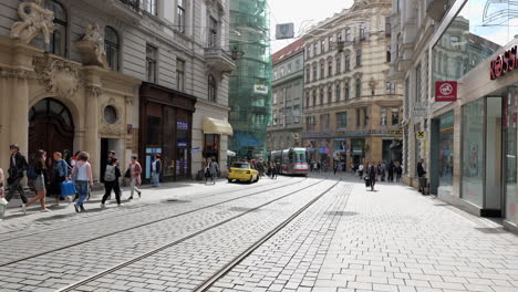 Red-Skoda-13T6-tram-car-on-the-Masarykova-street-in-Brno-with-people-walking-around