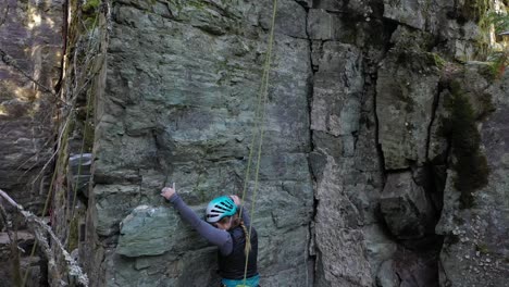 Woman-Climbing-Rock-In-Whitefish,-Montana,-USA---wide-shot