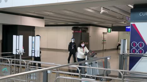 Los-Pasajeros-Con-Máscaras-Faciales-Llegan-A-La-Sala-De-Llegadas-Del-Aeropuerto-Internacional-Chek-Lap-Kok-En-Hong-Kong,-China