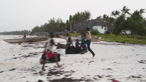 African-kids-jumping-over-tires-on-beach-in-poor-Zanzibar-village