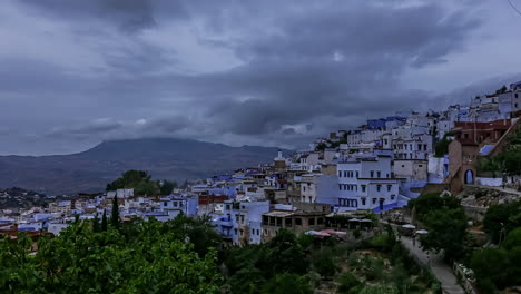 Time-lapse-shot-of-dark-clouds-flying-over-blue-city-of-Chefchaouen-in-Morocco-during-bad-weather