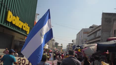 Salvadoreños-Caminan-Con-La-Bandera-Nacional-Durante-Una-Protesta-Pacífica-En-Las-Calles-De-La-Ciudad-Contra-El-Actual-Presidente-Nayib-Bukele---Cámara-Lenta