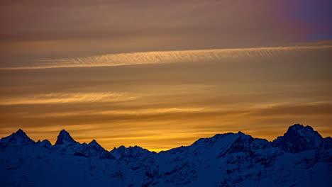 Toma-De-Tiempo-De-Nubes-Cirroestratos-Volando-Sobre-Una-Cordillera-Nevada-Durante-Una-Puesta-De-Sol-épica-En-El-Horizonte