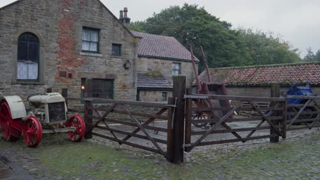 Bauernhaus-Einzäunung-Hof-Fordson-Modell-F-Traktor-Rote-Metallräder