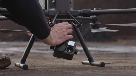 Un-Hombre-Colocando-Una-Cámara-Térmica-En-Un-Dron-Grande