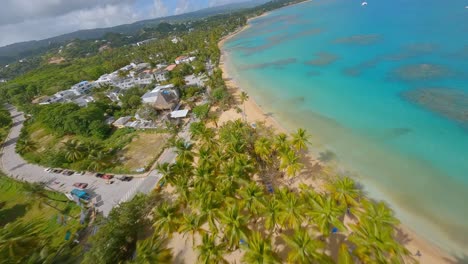 Fast-Fpv-Drone-flight-along-Playa-Punta-Poppy-with-tropical-palm-trees,-sandy-beach-and-turquoise-Caribbean-Sea-in-summer