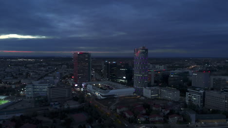 Vista-Aérea-Del-Distrito-De-Edificios-De-Oficinas-Del-Horizonte-De-La-Ciudad-Al-Atardecer-Bucarest,-Rumania