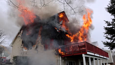 Flames-and-Smoke-Engulf-a-Three-Story-Home-with-Firefighters-on-Scene-Preparing-to-Fight-the-Blaze