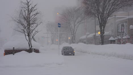 Starker-Schneefall-über-Den-Straßen,-Während-Autos-Langsam-Die-Straße-Hinunterfahren