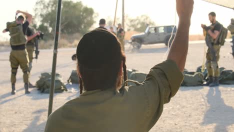 Un-Soldado-Religioso-Ultraortodoxo-Con-Un-Cigarrillo-En-La-Mano-Baila-Mientras-Los-Soldados-Se-Preparan-Para-Luchar-Con-Equipo