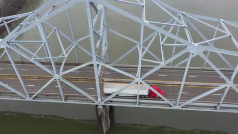 4K-Luftaufnahme-Eines-Roten-LKW-Fahrers-Auf-Einer-Brücke-über-Den-Fluss
