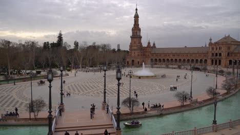 Panorámica-Sobre-La-Plaza-De-España-Con-Fuente-De-Agua-Y-Gente-Caminando.