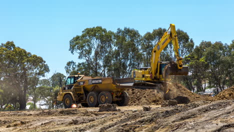 Time-lapse-of-an-excavator-filling-a-dump-truck-with-soil-at-a-housing-development-site