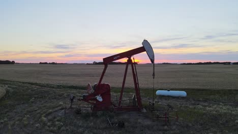 Una-Magnífica-Puesta-De-Sol-Detrás-De-Una-Bomba-De-Aceite-Roja-En-Las-Praderas-Canadienses