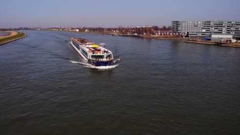 Aerial-Flying-Over-River-Noord-With-Spirit-Of-The-Danube-Approaching-On-Clear-Day-In-Alblasserdam