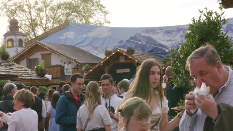 Crowds-eating-and-walking-around-in-Balvarian-outdoor-Spring-Fest-in-Stuttgart,-Baden-Wurttemberg,-Germany,-Europe,-afternoon-panning-view-angle