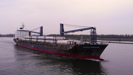 Aerial-View-Along-Starboard-Side-Of-Pacific-Fortune-Cargo-Ship-With-Circle-Dolly-Across-Forward-Bow-On-Oude-Maas