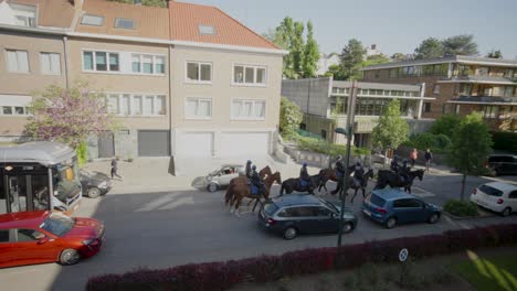 A-group-of-police-officers-and-their-horses-on-a-city-road-followed-by-public-transport-bus---Brussels,-Belgium