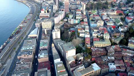 Aerial-dolly-out-rising-over-Valparaiso-hillside-buildings-and-funicular-in-Cerro-Concepcion-near-the-sea,-Chile