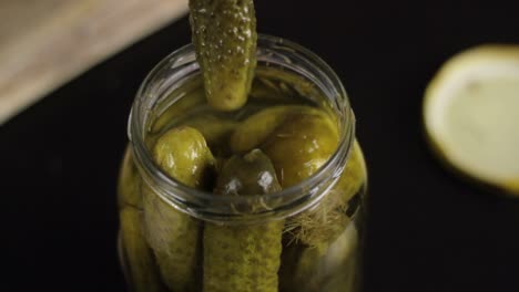 Taking-delicious-marinated-pickle-from-canned-jar,-close-up-view