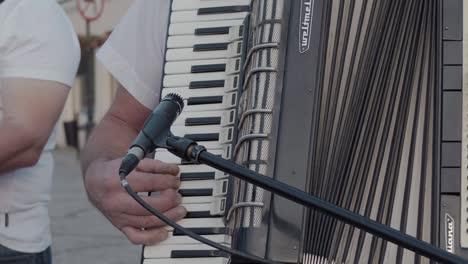 El-Músico-Con-Camisa-Blanca-Toca-El-Acordeón-En-La-Calle