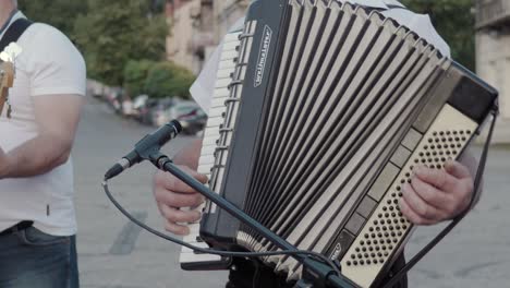 Dos-Músicos-Con-Una-Camisa-Blanca-Tocan-En-La-Calle