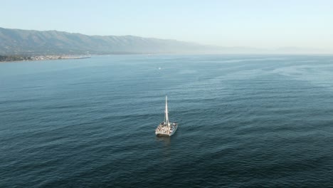 Antena-Circular-Cerca-De-Un-Velero-Lleno-De-Turistas-En-Crucero-Durante-Una-Hermosa-Puesta-De-Sol-En-El-Océano-Pacífico-Cerca-De-La-Costa-De-Santa-Bárbara,-California,-EE.UU.