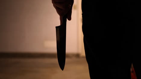 A-scary-slasher-killer-holding-a-terrifying-kitchen-knife-weapon-in-silhouette-before-attacking-his-murder-victim