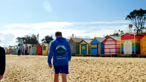 Tourists-walking-and-taking-photo-at-Brighton-Bathing-Boxes,-Melbourne,-Australia