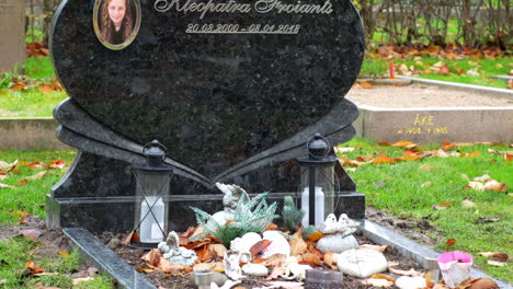 Tombstone-of-a-young-deceased-woman-in-Kviberg-Cemetery-in-Gothenburg,-Sweden---close-up