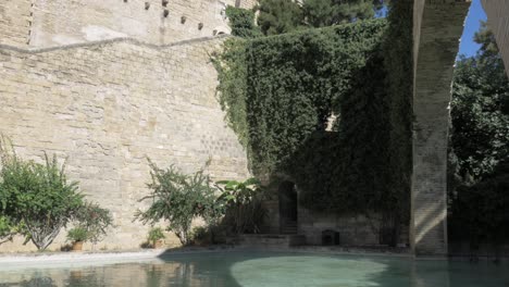 Royal-Palace-of-La-Almudaina-With-The-Arco-de-la-Drassana-in-View-Panning-Down-to-Pond